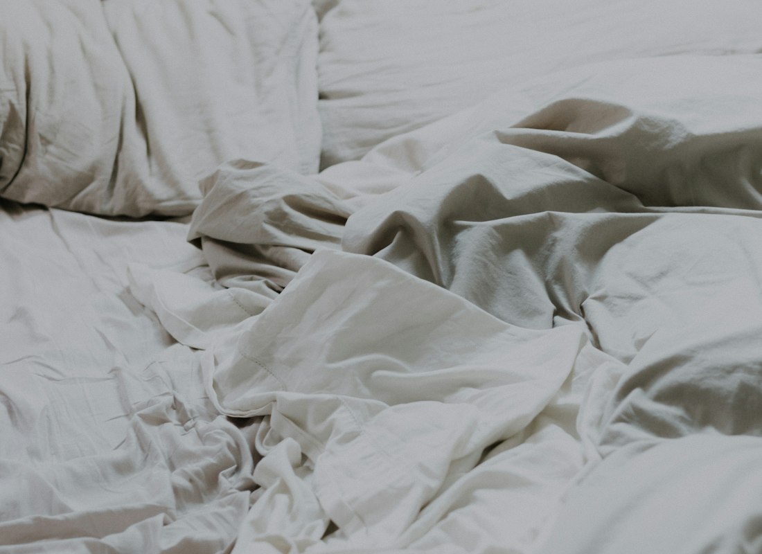 Folded white cotton pillows and duvet arranged as a bedding set