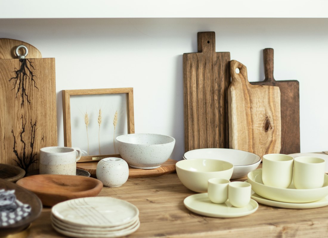 Set of white stoneware serving bowls on a wooden dining table