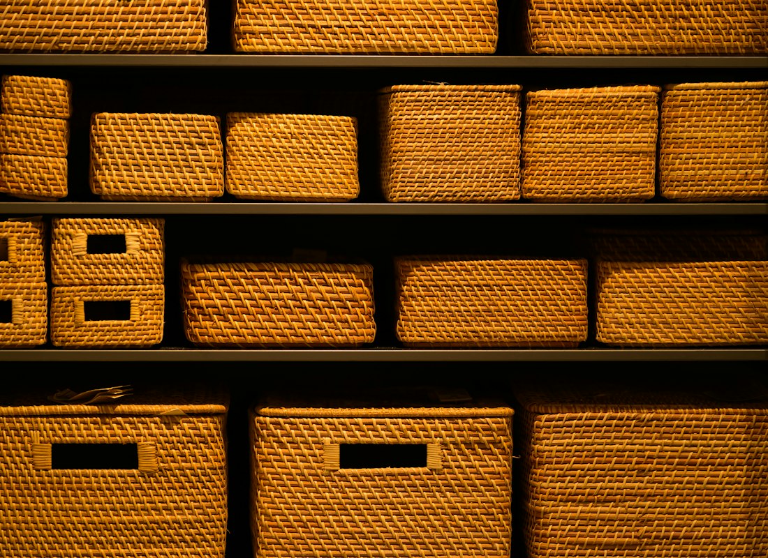 Rows of amber woven storage baskets on built-in shelving